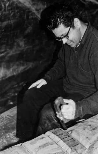 Makah artist Alex McCarty carving wood, in black and white