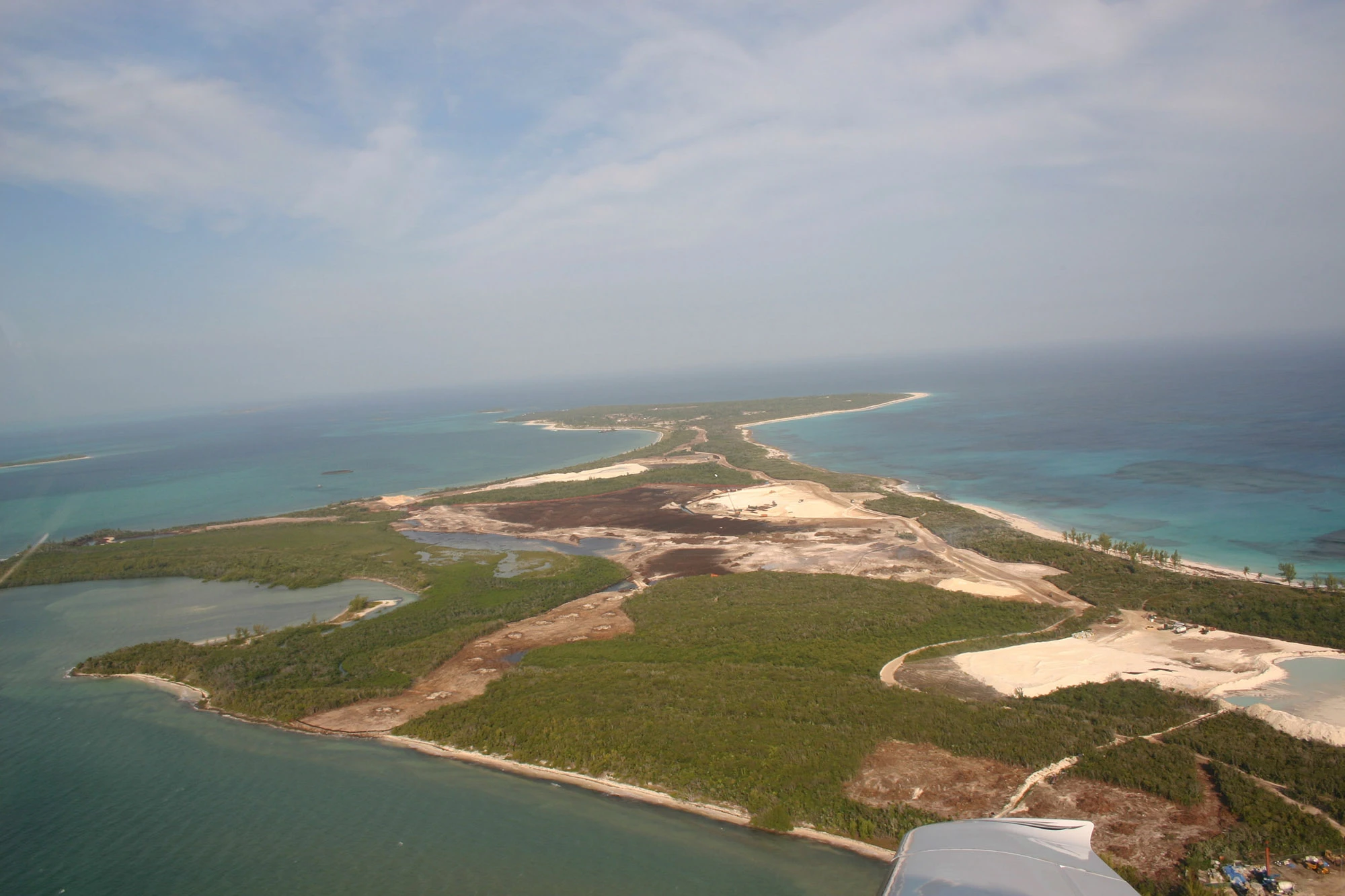 An aerial view of Great Guana Cay's Joe's Creek and its surrounding mangrove wetlands being cleared and dredged in the early stages of Baker's Bay Golf & Ocean Club's marina and golf course construction, the same operation the monitoring reports below were written to track.