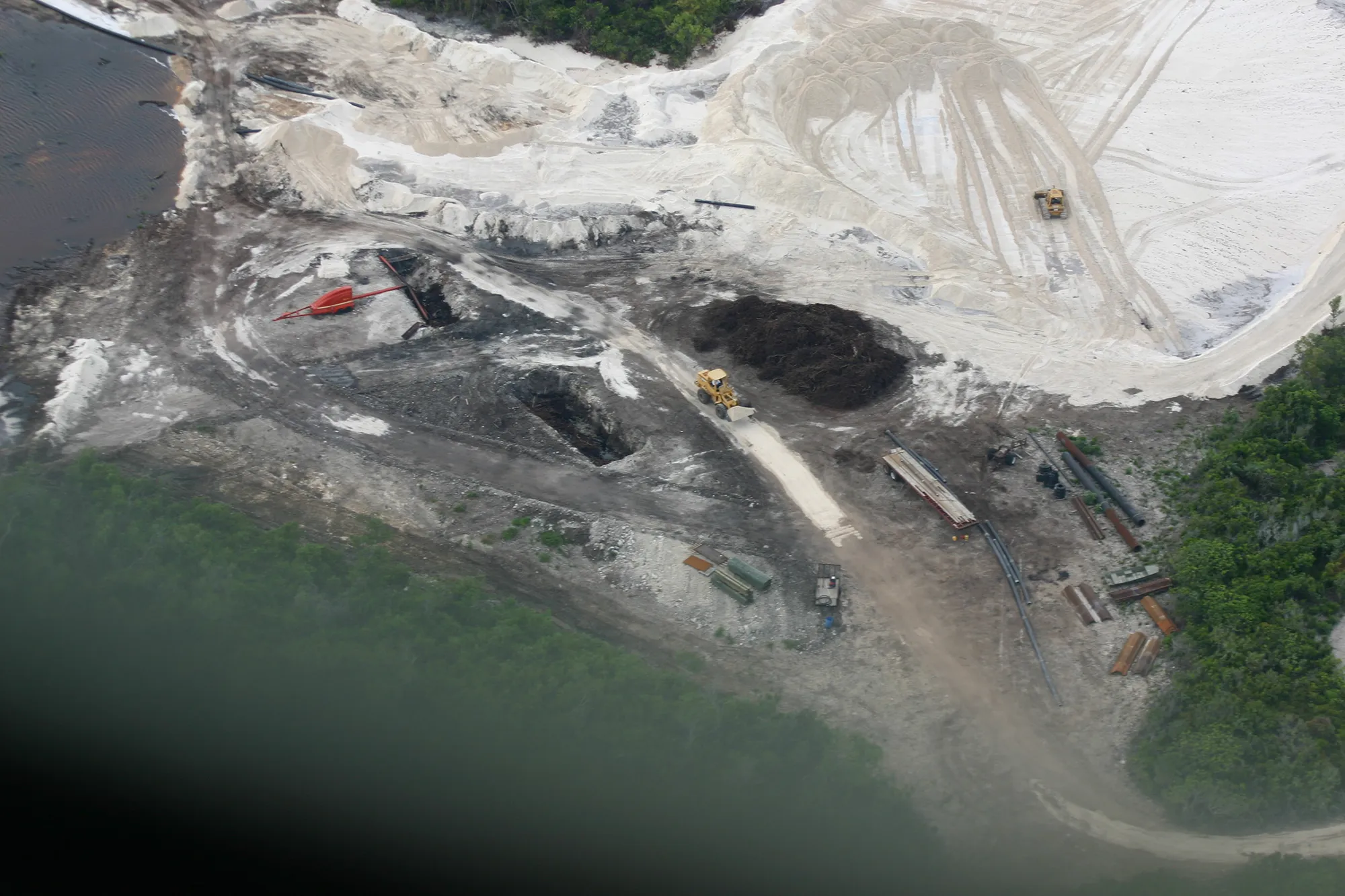 Aerial view of heavy equipment, pipe and dredged spoil where mangroves were cleared for the Bakers Bay marina