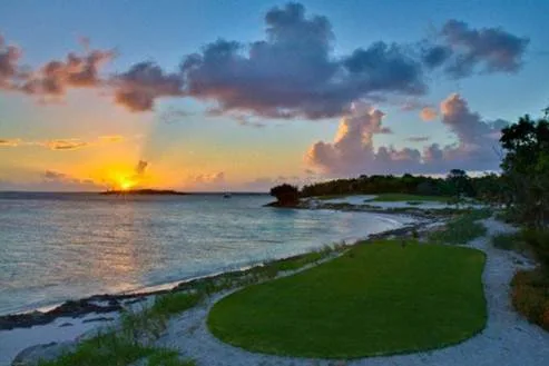 A manicured golf green beside the beach at sunset, Baker's Bay