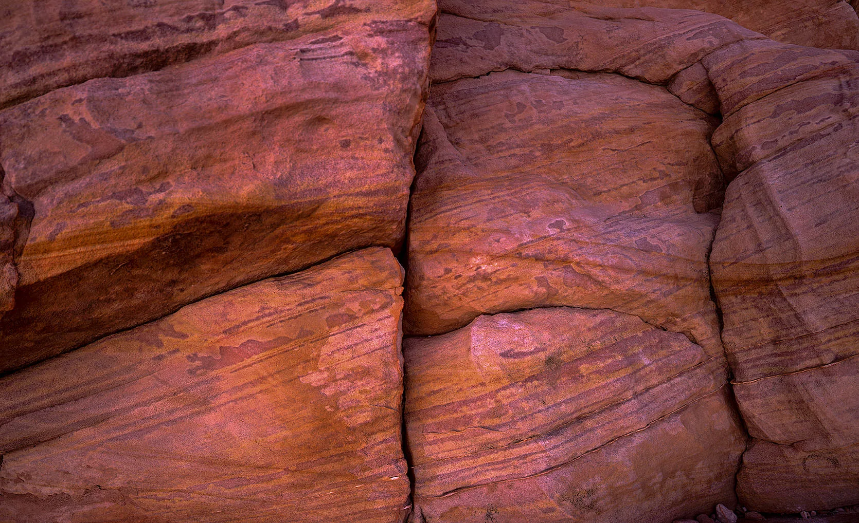 Close-up of cracked, layered red and pink sandstone in Valley of Fire State Park, Nevada.
