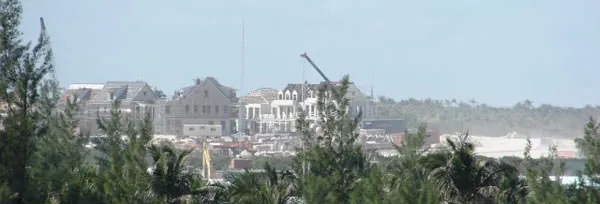 Large new resort buildings and a construction crane rising above the trees on Great Guana Cay.