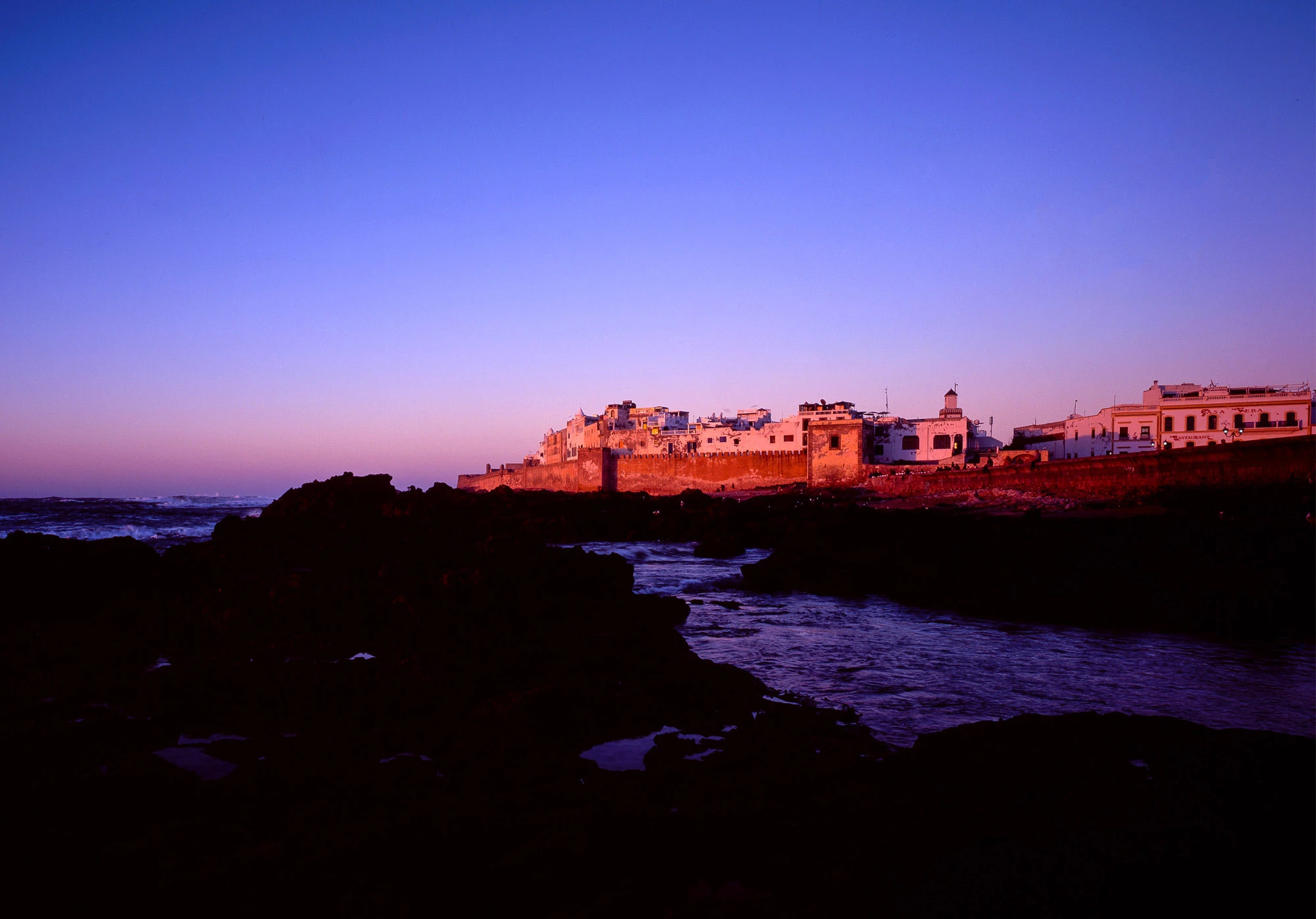Essaouira's walled medina glowing in sunset light above the Atlantic, Morocco