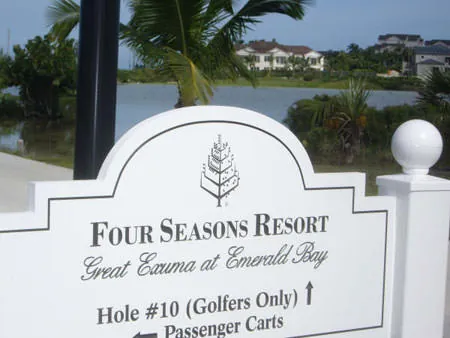 A Four Seasons Resort Great Exuma sign beside a flooded golf course at Emerald Bay.