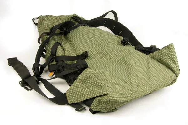 A green GoLite ultralight frameless backpack laid out empty
