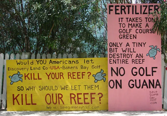 Guana Signs. One says: Fertilizer, it take tons to make a golf course green. Only a tiny bit will destroy an entire reef. NO GOLF ON GUANA.