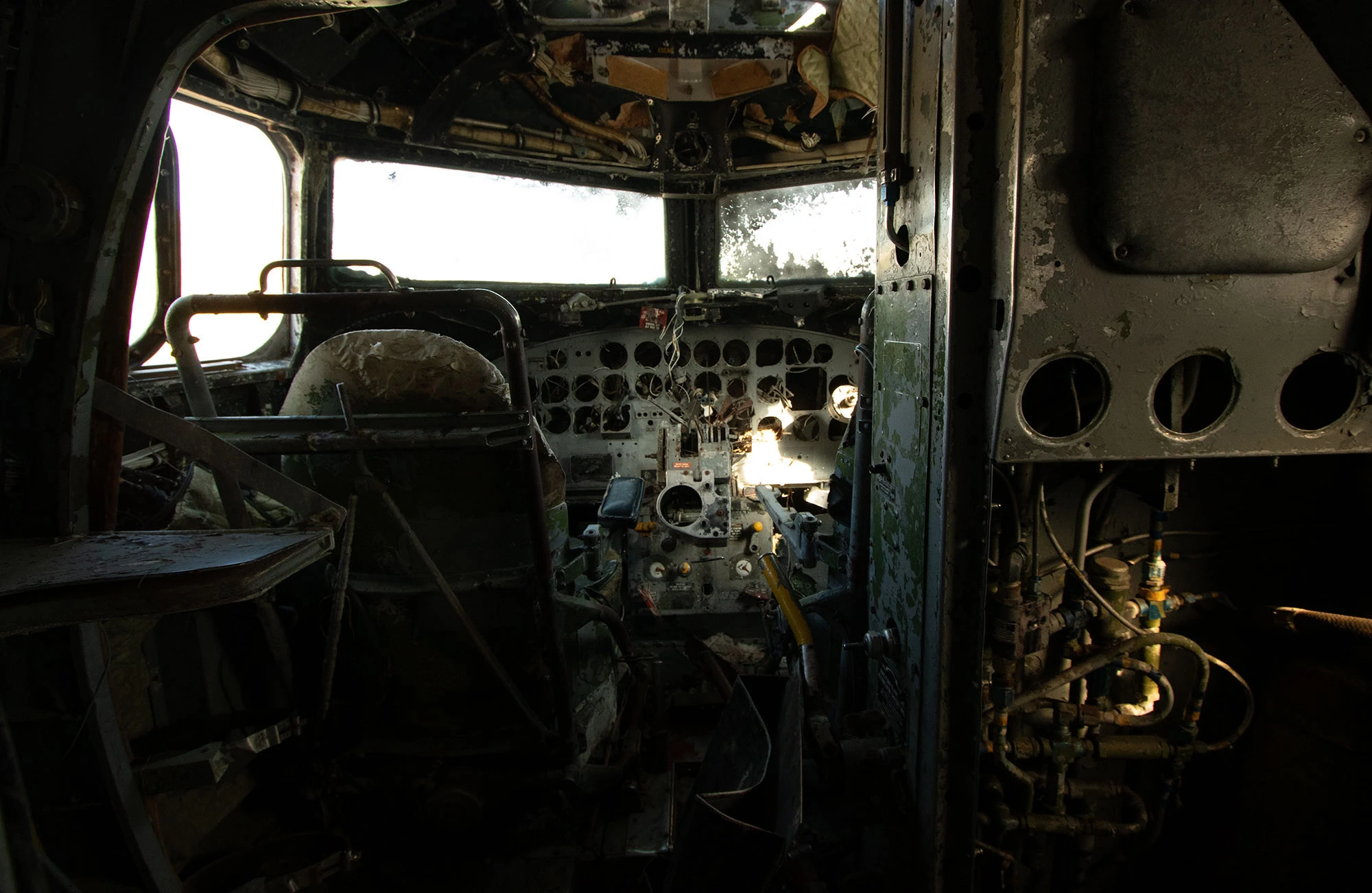 Interior view of a US Navy Douglas C-117D transport aircraft on the grounds of Hnjótur Farm near the Látrabjarg Hotel in Iceland, a relic of the Cold War era preserved above the turquoise waters of Patreksfjörður fjord.