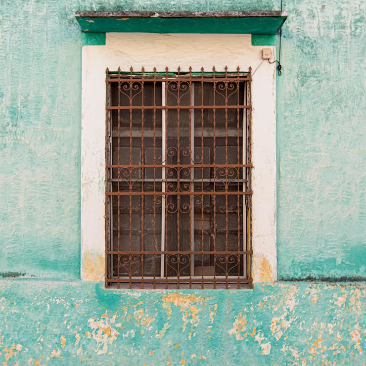 Grated window with faded mint paint, photographed in Mérida, Yucatán