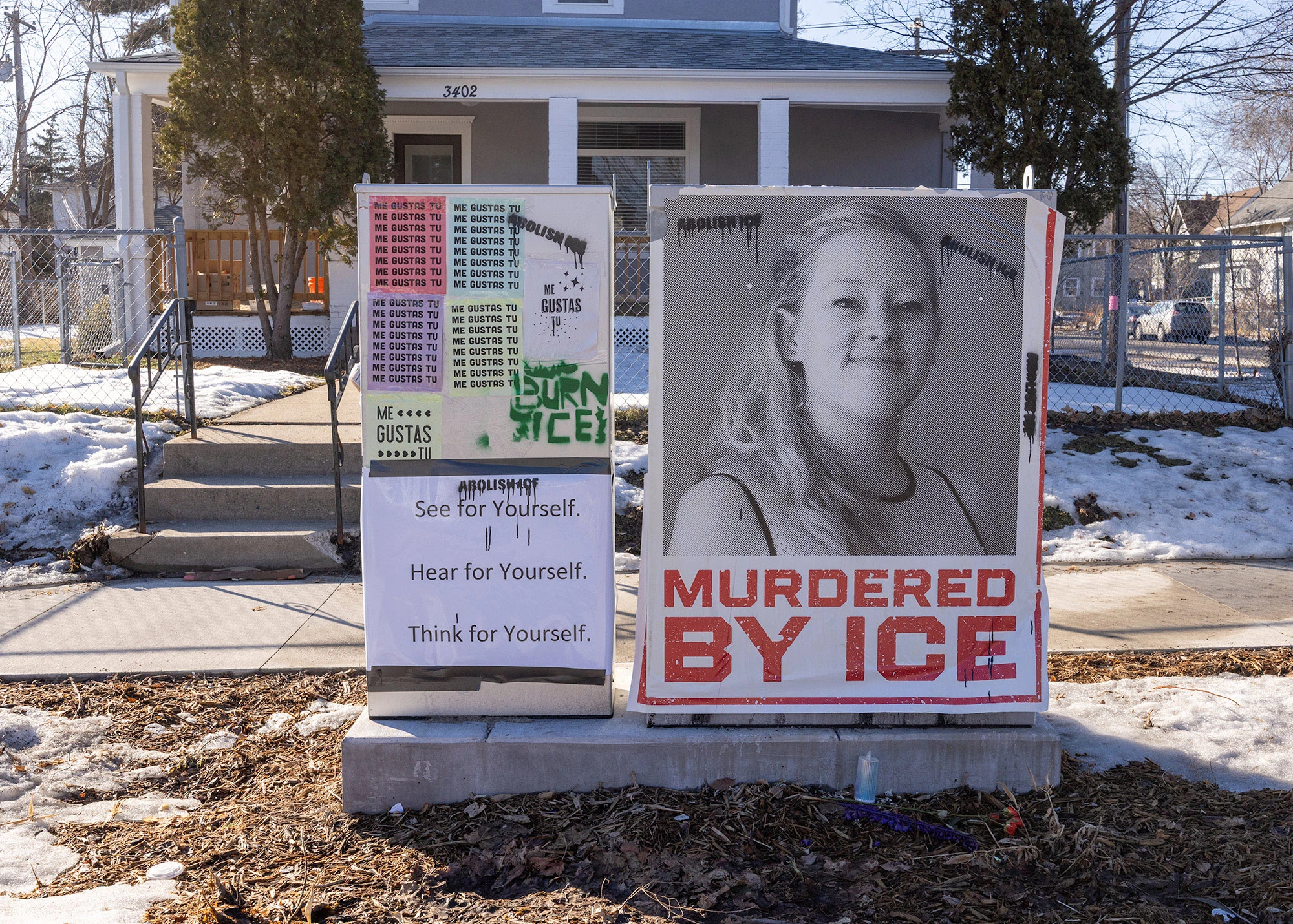 A large poster pasted in a Minneapolis neighborhood shows a black-and-white portrait of Renee Good with bold red text reading 'Murdered by ICE,' part of community reaction to her fatal shooting by a federal agent.