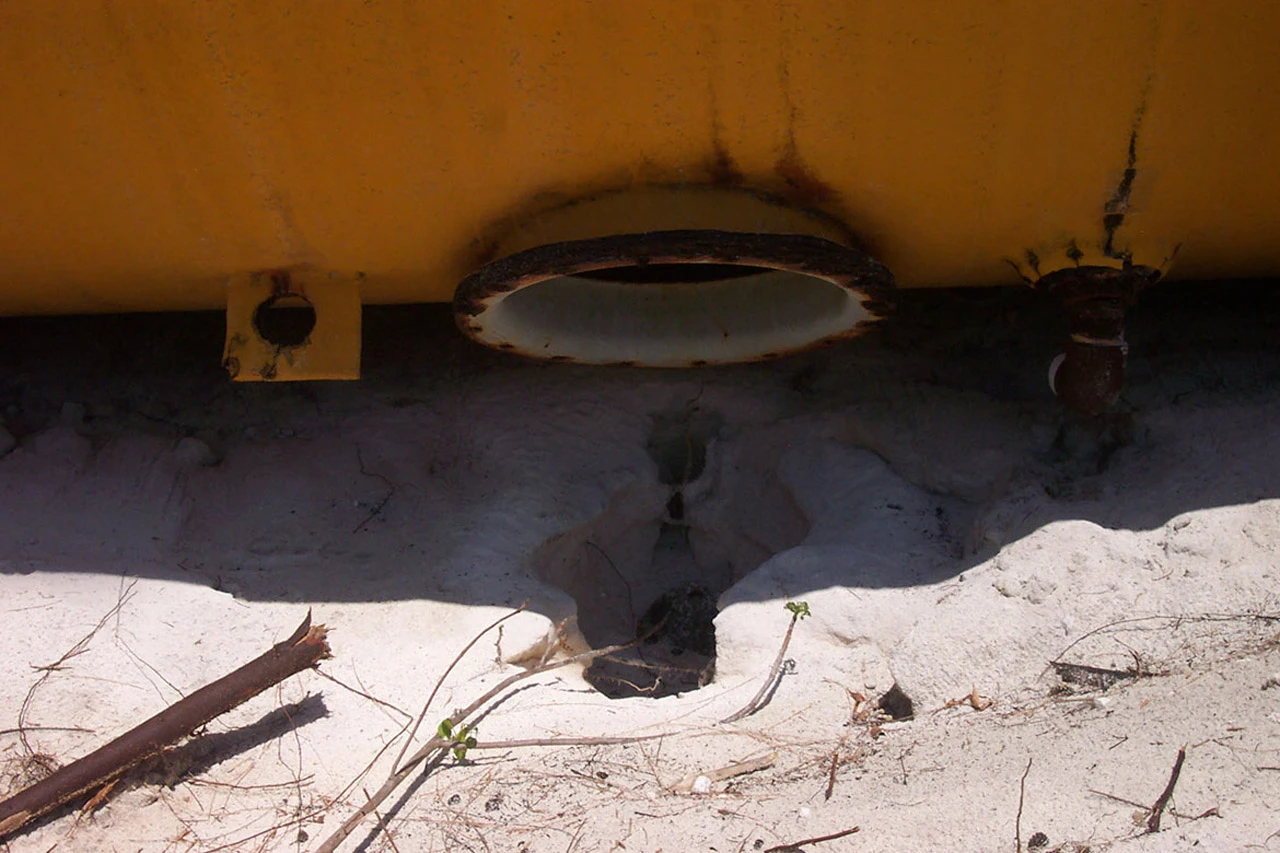Oil leaking onto the ground and into the porous limestone at Baker's Bay, the same unfiltered geology that connects surface contamination directly to the groundwater and, ultimately, the coral reef.
