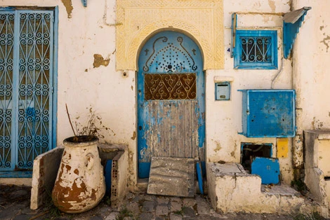 Whitewashed blue-and-white hilltop village of Sidi Bou Said, Tunisia, overlooking the Mediterranean under bright afternoon light.