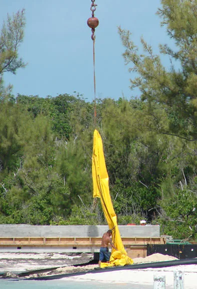American Bridge workers remove the silt curtain, which was haphazardly used to minimize silting into the nearshore environment during dredging and construction