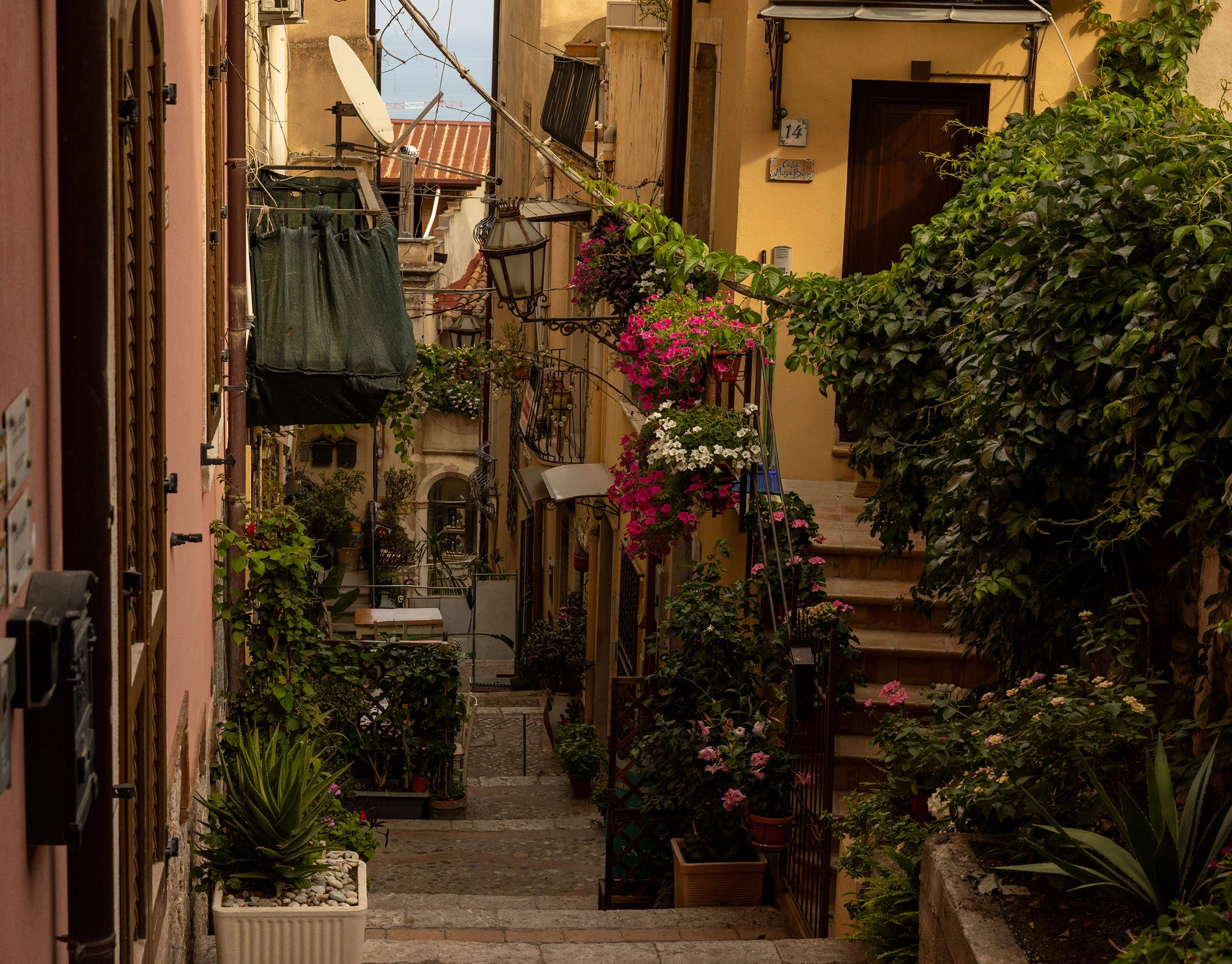 A narrow, flower-filled alley in the old town of Taormina, Sicily.
