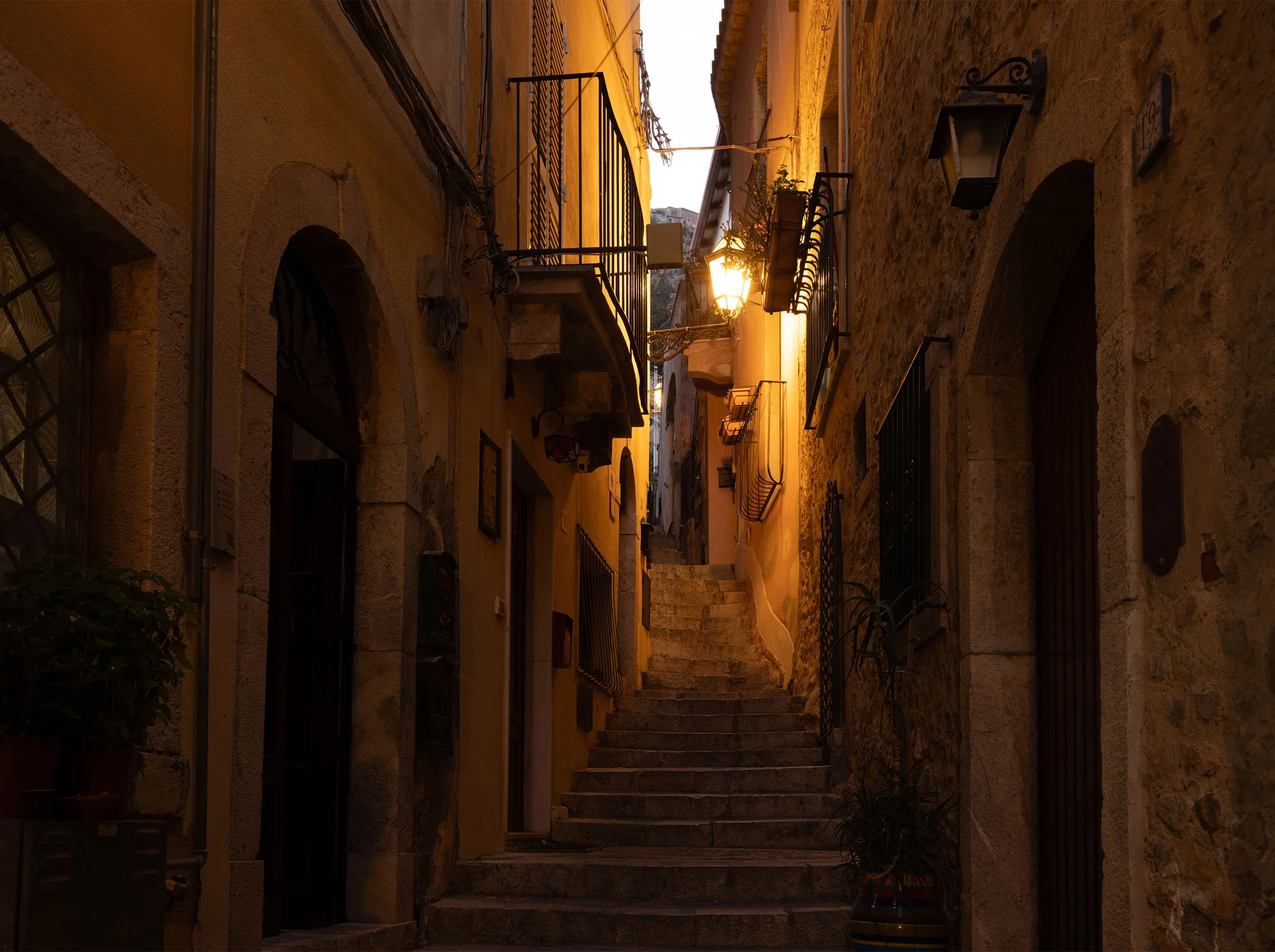 A steep stone staircase climbing through Taormina, Sicily.