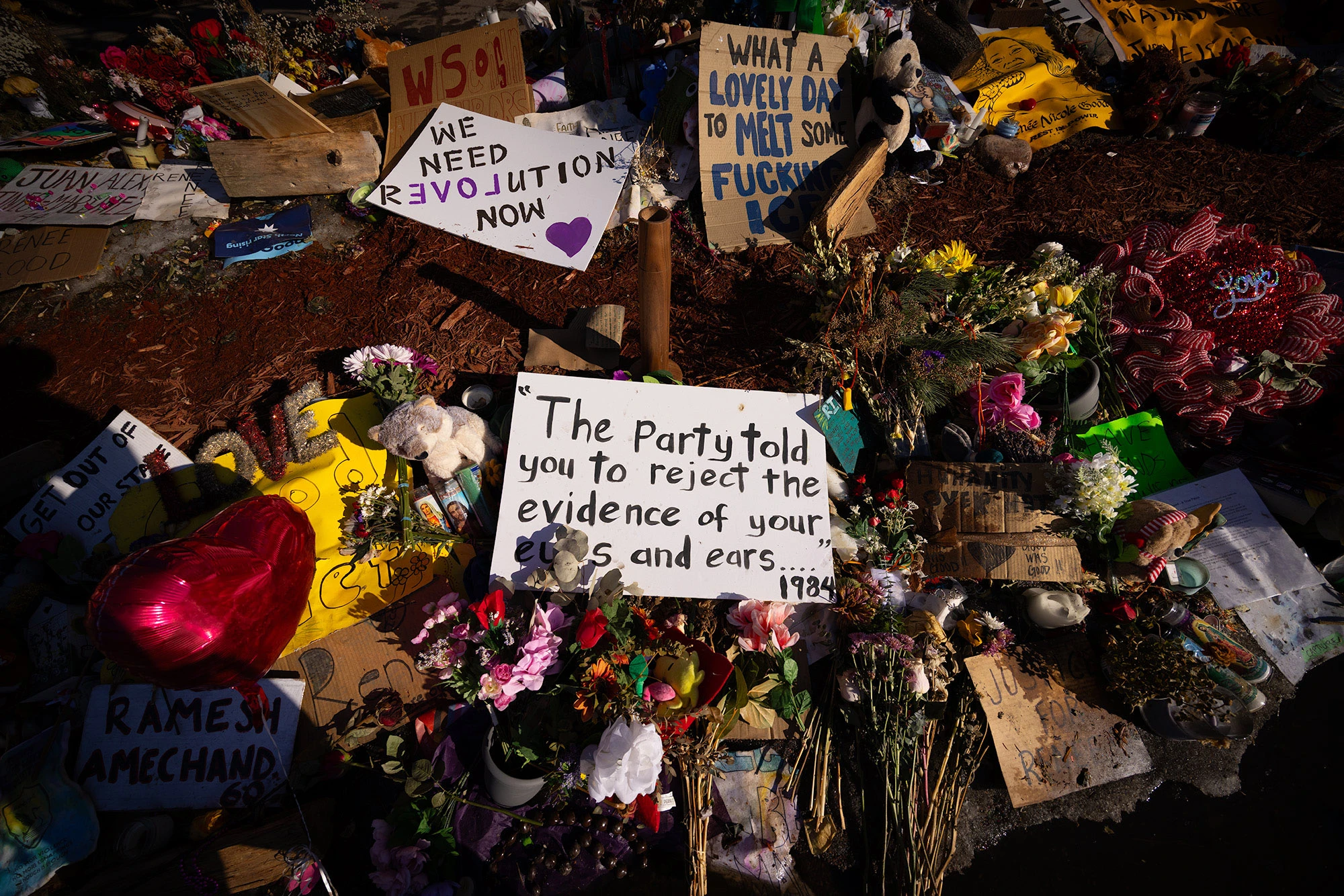 A protest sign placed at the Alex Pretti memorial reads 'The party told you to reject the evidence,' displayed among flowers, candles and other messages left by demonstrators.