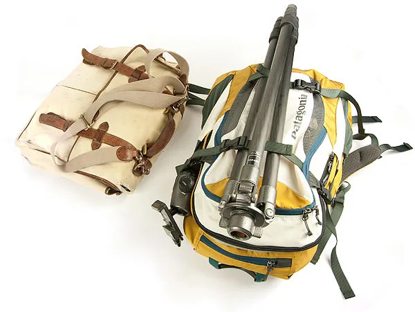 A canvas camera satchel beside a yellow Patagonia pack rigged to carry a tripod