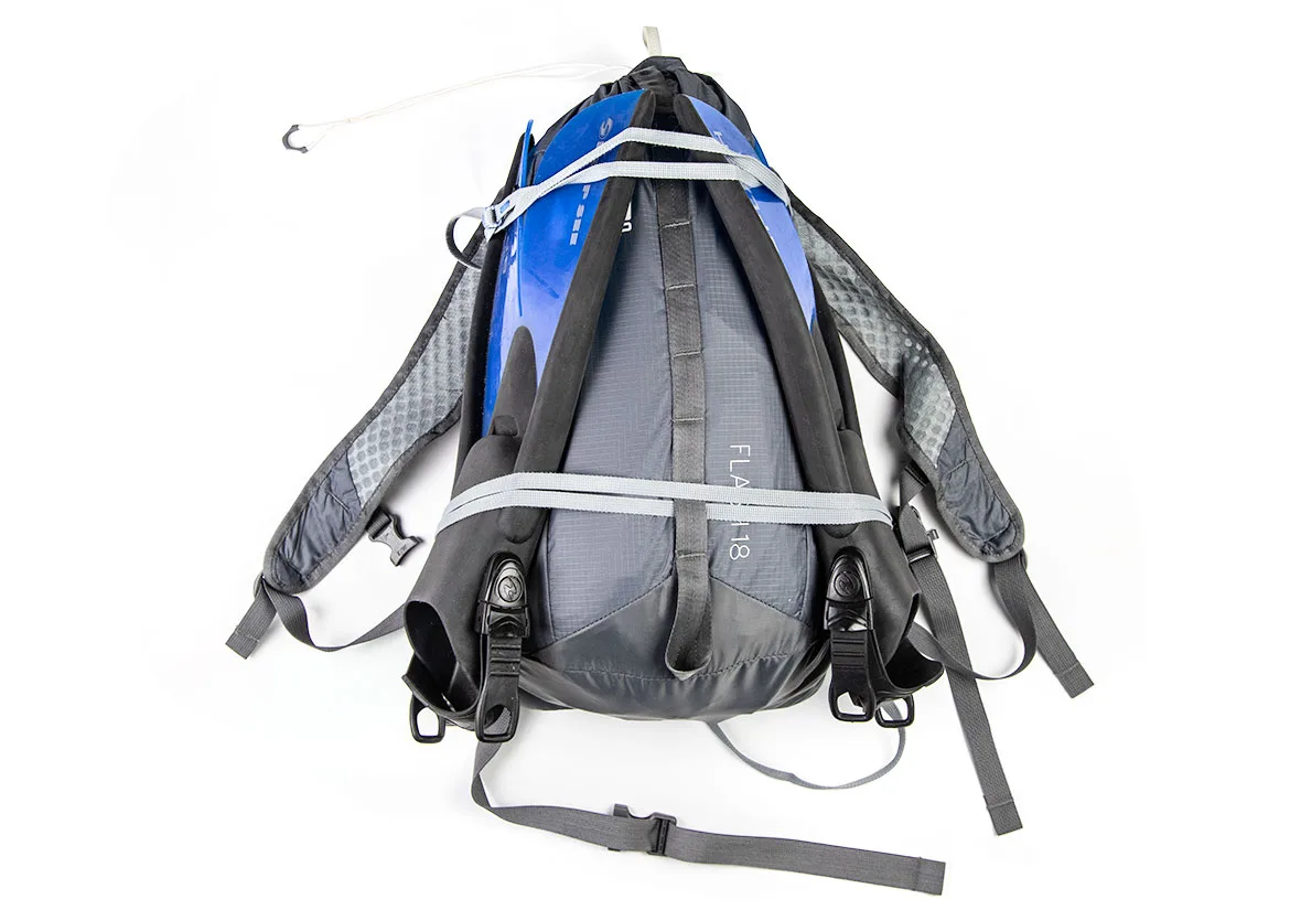 The harness side of an ultralight REI Flash 18 daypack, a blue pad strapped to its back